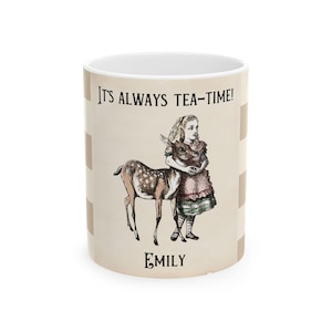 Puede incluir: Taza de cerámica blanca con un patrón a cuadros y un gráfico de Alicia en el País de las Maravillas sosteniendo un cervatillo. La taza tiene el texto "It's Always Tea-Time!" y el nombre "Emily" impreso en ella.