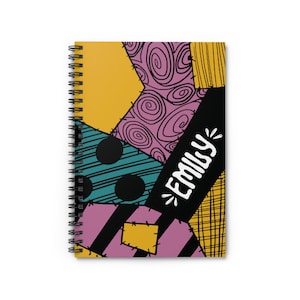 Puede incluir: Una libreta de espiral con un diseño de patchwork colorido con amarillo, rosa, azul verdoso, negro y blanco. El texto "Emily" está escrito en blanco sobre un fondo negro.