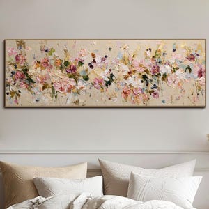 Peut inclure: Peinture florale rectangulaire avec un cadre doré et un fond beige. L'œuvre d'art présente une variété de fleurs roses, blanches et vertes. Le tableau est au-dessus d'un lit avec des oreillers blancs et une couverture beige.