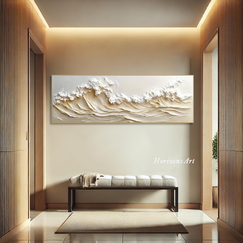 May include: A white and gold textured wall art piece depicting waves crashing. The art is framed in a thin gold frame and hangs on a wall in a modern home interior. The text "HorizonsArt" is visible in the bottom right corner of the image.