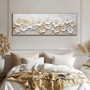 K&ouml;nnte beinhalten: Ein langes, horizontales Leinwandbild mit einem wei&szlig;en und goldenen Blumendesign. Die Blumen sind 3D und haben eine strukturierte Oberfl&auml;che. Der Hintergrund ist hellbeige.