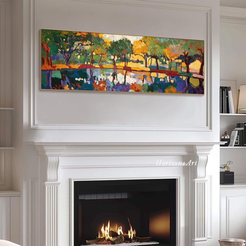 May include: A colorful abstract painting of a landscape with trees reflected in a body of water. The painting is framed and hanging above a fireplace.