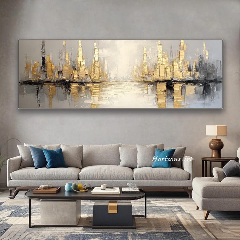 Puede incluir: Pintura abstracta de una ciudad con acentos dorados. La pintura es de estilo moderno y presenta un reflejo de la ciudad en el agua. La pintura est&aacute; colgada en una pared en un sal&oacute;n.