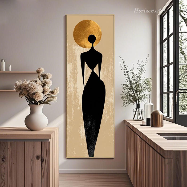 Puede incluir: Impresi&oacute;n art&iacute;stica abstracta que presenta una figura negra con un halo dorado sobre un fondo beige. La figura lleva un vestido negro. La obra de arte est&aacute; enmarcada en un marco dorado y es un rect&aacute;ngulo vertical.