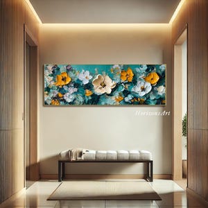 May include: A large abstract painting of yellow and white flowers on a teal background. The painting is framed and hanging on a wall in a hallway.
