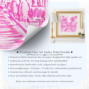 May include: A fine art giclee print featuring a vibrant hot pink and white painterly illustration of a palm tree-lined path. The artwork is displayed in a gold frame on a white mantel next to a gold lamp and a small vase of white flowers.