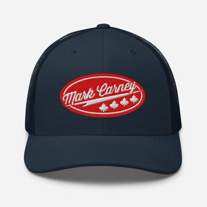 May include: A navy blue trucker hat with a red oval patch that says "Mark Carney" in white with a white maple leaf design.