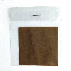 May include: A brown fabric swatch in a clear plastic sleeve with a metal fastener.