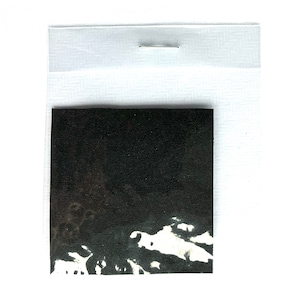 Op de afbeelding: Een zwart stofstaal met witte verfspatten. De stof is getextureerd en heeft een ruw oppervlak.