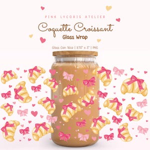 Puede incluir: Un tarro de cristal con tapa de madera, lleno de un líquido marrón claro. El tarro está decorado con ilustraciones de cruasanes atados con lazos rosas y corazones rosas. El texto "Coquette Croissant Glass Wrap" está en la parte superior.