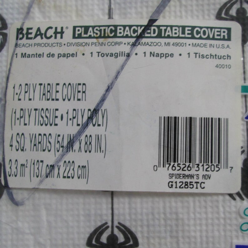 May include: White plastic-backed table cover with a spider web design. The label reads "BEACH PLASTIC BACKED TABLE COVER" and includes dimensions of 54 inches by 88 inches. The product is a 1-2 ply table cover.