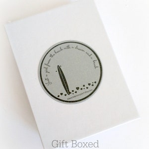 May include: A white gift box with a silver circle sticker that says "Just a girl from the beach with a dream and a brush" with a surfboard graphic and small hearts. The text "MancMarjungArt.etsy.com" is below the graphic. The box is labeled "Gift Boxed".