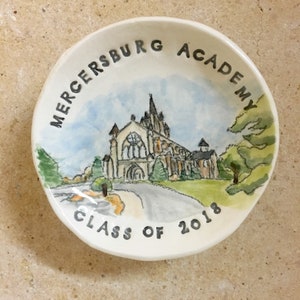 May include: A white ceramic dish with a watercolor painting of a building and the text "Mercersburg Academy Class of 2018".