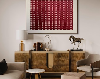 May include: A living room interior design featuring a brown wooden cabinet, a white sofa, a gold side table, a pink ottoman, a gold chair, and a framed abstract artwork with a red geometric pattern.