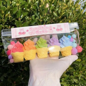 May include: Six colourful ice cream cone shaped sweets with a pink and white background with the text "Sweetheart Bear" in pink letters.