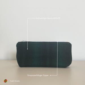 May include: A dark green zippered pouch made of high-quality cotton fabric. The pouch has a zipper closure and is perfect for storing small items.