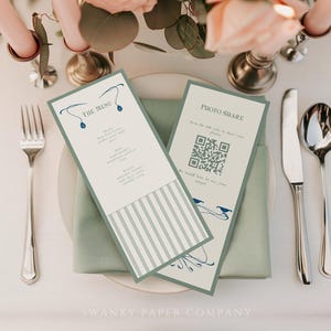 May include: Elegant wedding table setting with menu and photo share cards. The cards are light green with blue accents and text. Silverware, a white plate, and a green napkin are also visible. Floral arrangement and candles complete the scene.