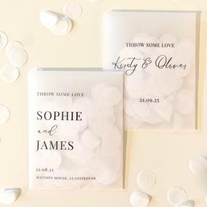 Op de afbeelding: Twee doorschijnende witte zakjes gevuld met witte confetti. Op elk zakje staat de tekst "THROW SOME LOVE". E&eacute;n zakje leest "Sophie and James" met een datum en locatie. De andere leest "Kirsty & Oliver" met een datum.