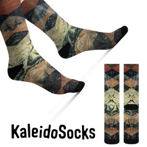 May include: A pair of colourful socks with a geometric pattern. The socks are brown, beige, and black with a kaleidoscope design. The socks are shown on a model's foot with the word "KaleidoSocks" printed below.