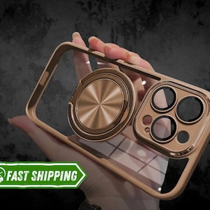 May include: A gold phone case with a clear back and a gold ring holder. The case has a raised camera bump with three lenses.