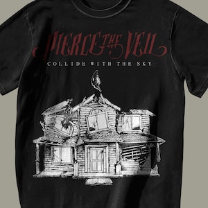 May include: Black t-shirt with a white graphic of a house with broken windows and a bird on the roof. The text "PIERCE THE VEIL" and "COLLIDE WITH THE SKY" is printed in red on the shirt.