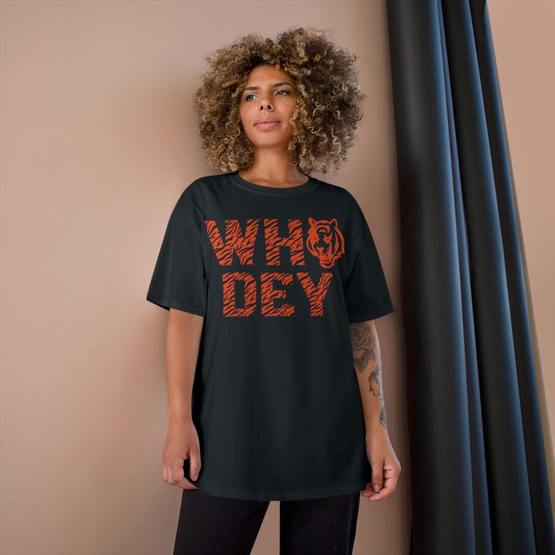 May include: Black t-shirt with an orange tiger stripe design that says "WHO DEY" with a tiger head graphic.
