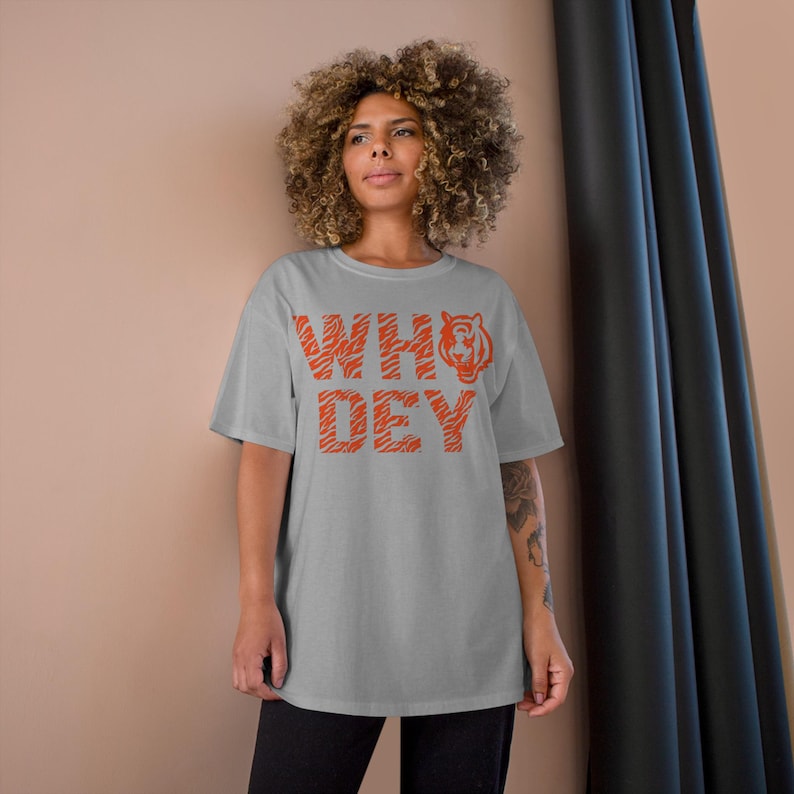 May include: A gray t-shirt with an orange tiger stripe design and the text "WHO DEY" printed on the front.