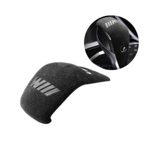May include: A black suede-like gear shift knob cover featuring the embossed letters M and W in a stylized font. The cover is designed to fit over a car gear shifter, which is shown in a circular inset with a visible P for park setting.