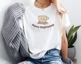 May include: White t-shirt with a cartoon illustration of a coffee cup with a smiling face surrounded by coffee beans. The text "More Espresso" is printed below the cup.