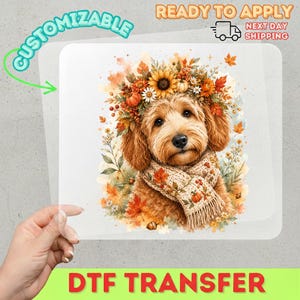 May include: A DTF transfer sheet featuring a golden-brown dog wearing a floral crown of sunflowers, pumpkins, and autumn leaves, paired with a beige knit scarf decorated with small pumpkins and leaves, set against a watercolor-style fall background.