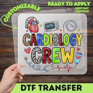 May include: A clear DTF transfer sheet featuring the text CARDIOLOGY CREW in colorful, patterned letters. Graphics include a human heart with headphones, a medical monitor, a stethoscope, an IV bag, and an EKG line, all in vibrant colors.