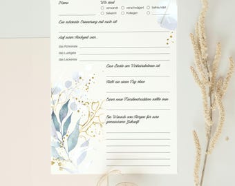 May include: A printable wedding guest book with a floral design in shades of blue and gold. The text on the page includes questions for the couple to answer about their relationship.