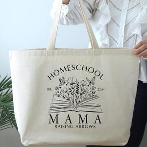 Puede incluir: Una bolsa de lona beige con texto negro y un dise&ntilde;o gr&aacute;fico. El texto dice "Homeschool Mama Raising Arrows" con un libro y un gr&aacute;fico de flores. El libro tiene el texto "PR. 22:6".