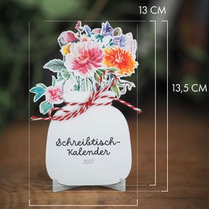 Der Tischkalender mit Maßangaben von 13 mal 13,5 Zentimetern in der Höhe und 9 Zentimetern in der Breite.