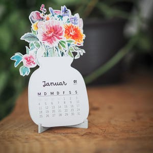 Ansicht des Januar-Kalenderblatts mit dem floralen Motiv in einer dunklen Umgebung.
