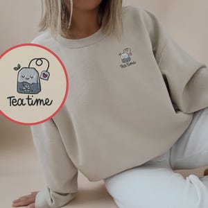 ティータイムの刺繍入りスウェットシャツ、紅茶愛好家への贈り物、紅茶中毒者の心地よいセーター、アフタヌーンティーの服装、ティーポット、紅茶を飲む人、ティーバッグのアパレル