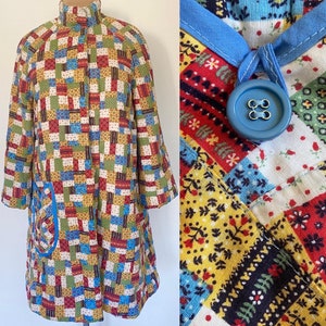 May include: A long, patchwork coat with a blue collar and a blue button. The coat is made of a variety of fabrics with different patterns, including floral, geometric, and plaid.