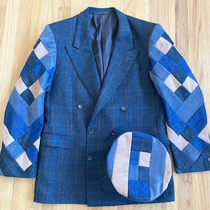 May include: A blue double-breasted blazer with patchwork sleeves and a matching hat. The blazer features a plaid pattern and a double-breasted design. The sleeves and hat are adorned with a patchwork design in shades of blue and beige.