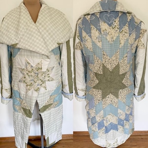 May include: A long coat constructed from quilted fabric featuring a patchwork design of blue, white, and sage green floral and plaid patterns. The garment includes a wide shawl collar, long sleeves, and a prominent star motif on the back panel.