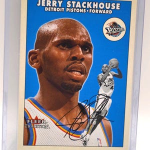 Puede incluir: Tarjeta de baloncesto de Jerry Stackhouse de los Detroit Pistons. La tarjeta presenta un retrato de Stackhouse y una foto de acción. La tarjeta está en una funda protectora. El texto incluye "Jerry Stackhouse Detroit Pistons Forward" y el logo Fleer Tradition.