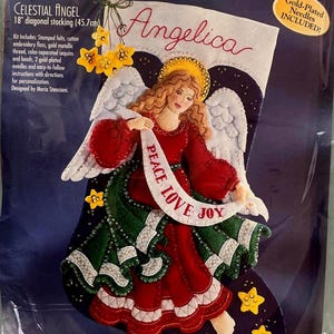 May include: Felt appliqué kit for a Celestial Angel Christmas stocking, 18-inch (45.7 cm) diagonal. The design features an angel in a red dress holding a banner with "Peace Love Joy". Includes stamped felts, floss, sequins, beads, and needles.
