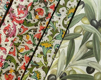 May include: Four strips of decorative paper with floral patterns in shades of red, green, yellow, and blue. The paper is on a background of white paper with a pattern of olive branches and olives in shades of green and black.