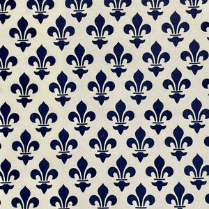 Puede incluir: Un patr&oacute;n repetido de s&iacute;mbolos de flor de lis azul marino sobre un fondo crema. El dise&ntilde;o est&aacute; espaciado uniformemente, creando una est&eacute;tica sim&eacute;trica y cl&aacute;sica. La imagen es una vista de cerca del patr&oacute;n.