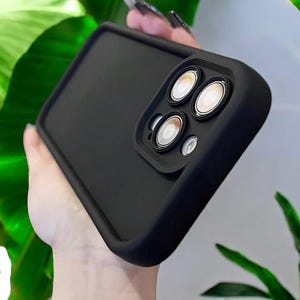 May include: Black phone case with a raised camera lens cover. The cover has three circular cutouts for the camera lenses.