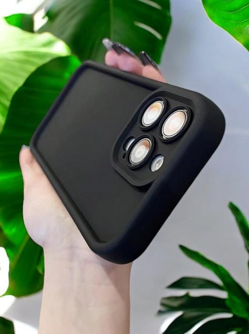 May include: Black phone case with a raised camera lens cover. The cover has three circular cutouts for the camera lenses.
