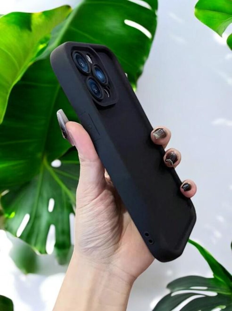 May include: A black phone case with a raised camera lens protector. The case has a smooth, matte finish.