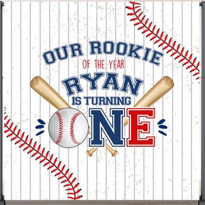May include: A baseball-themed backdrop with the text "Our Rookie of the Year Ryan is Turning One." The design includes a baseball, bats, and red stitching accents on a white and gray striped background. Perfect for a first birthday celebration.