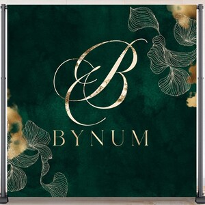 Op de afbeelding: Een donkergroene achtergrond met gouden bloemaccenten en de naam "BYNUM" in gouden letters. Een grote gouden letter "B" is gecentreerd boven de naam. De achtergrond wordt ondersteund door een zwart metalen frame. De woorden "Oh! My WRAPPERS" staan in een cirkel rechtsboven.