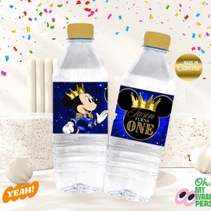 May include: Two clear plastic water bottles with blue and gold labels featuring a cartoon Mickey Mouse dressed as a prince. The labels say "Jason Turns One".