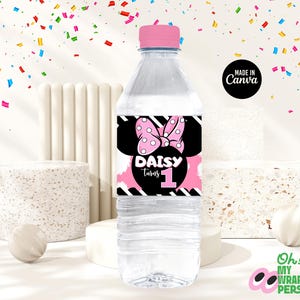 May include: A clear plastic water bottle with a pink and black label featuring a cartoon mouse with a pink bow and the text "Daisy turns 1".